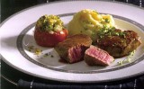 Wildzwijnmedaillons met aardappelpuree en geroosterde tomaten.