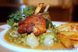 Kippenboutjes met witbier, goud gebakken aardappelen en erwten op zijn Frans